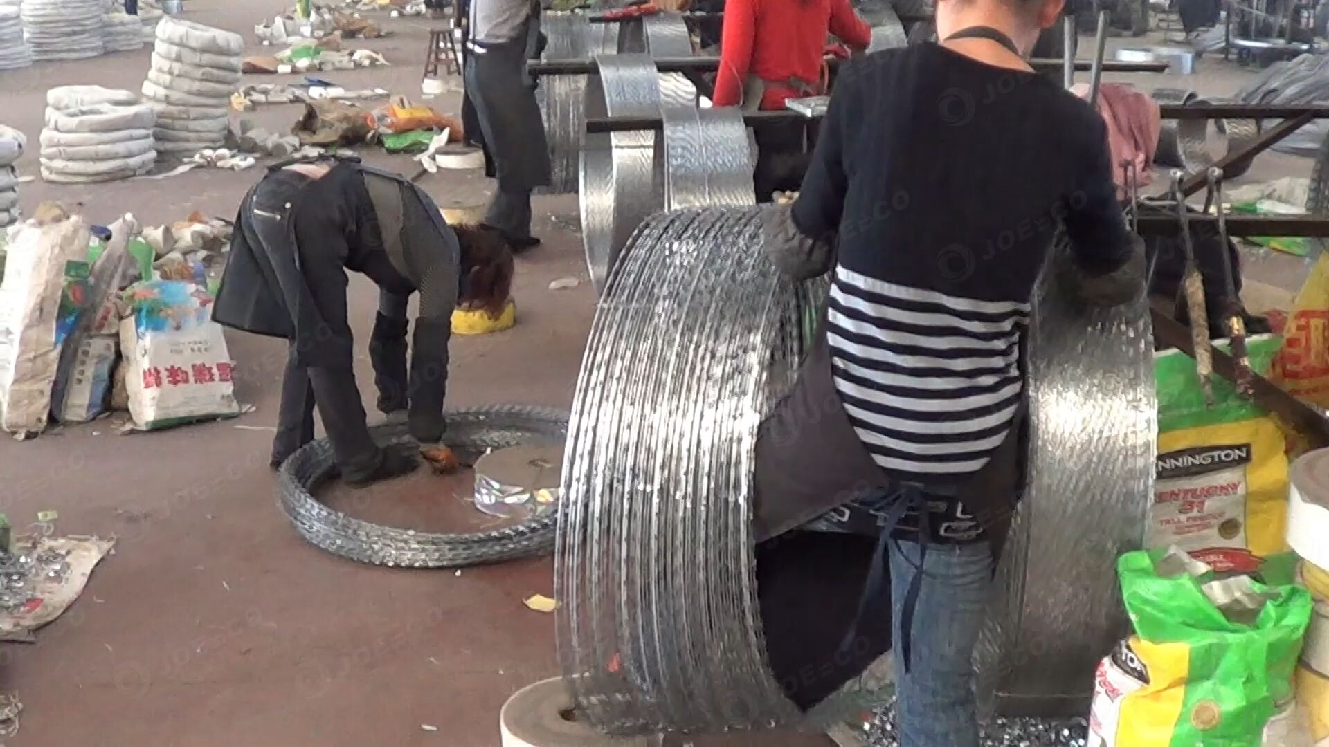The workers are packaging the coiled razor blade wire. thumbnail